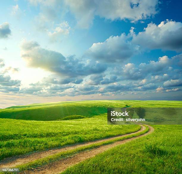 Summer Landscape With Green Grass Road And Clouds Stock Photo - Download Image Now - Grass, Dirt Road, Hill