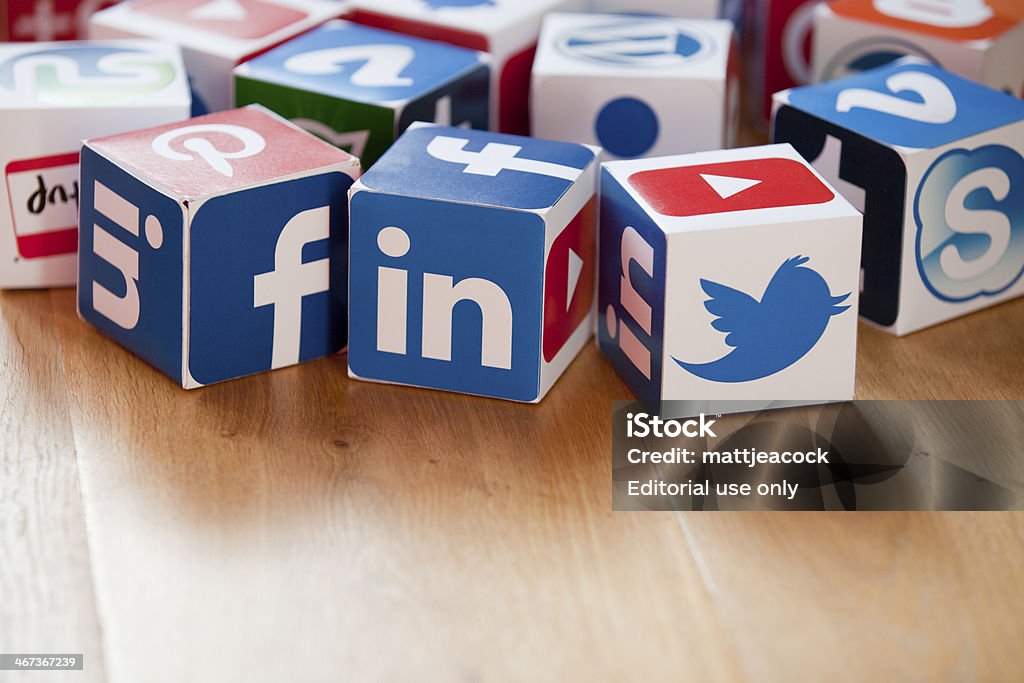 Social media cubes on a wooden background London, United KIngdom- February 3, 2014: Social media logos printed onto handmade cubes. Logos include Facebook, linkedin, twitter. Social media uses web and mobile technology to connect people LinkedIn Stock Photo