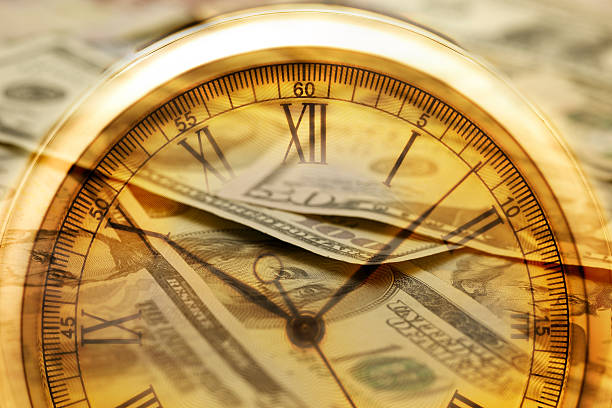 Time and Money. Clock in US dollars - Stock Image stock photo