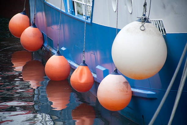 Side view of a mooring fishing boat with hanging buoys.