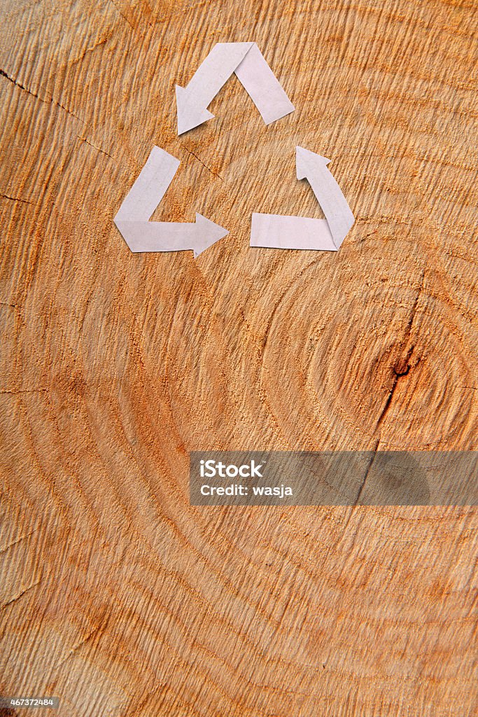 Close-up wooden cut and recycle symbol Close-up wooden cut and paper recycle symbol 2015 Stock Photo