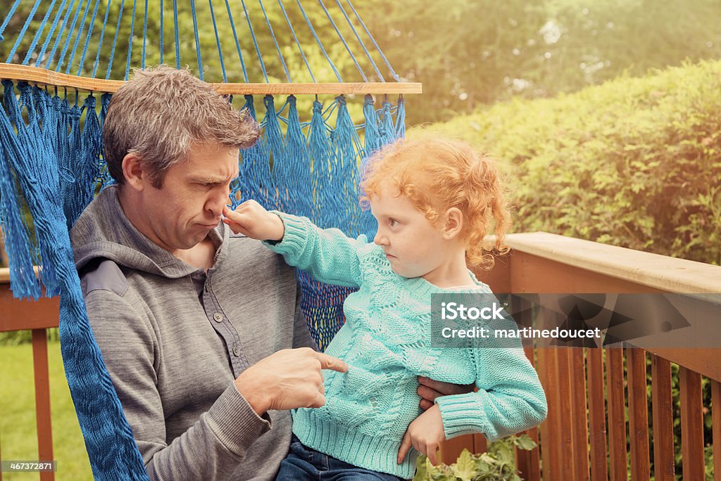 El uso de un Dad y poco Pelirrojo girl defendiendo en una hamaca. - Foto de stock de 4-5 años libre de derechos