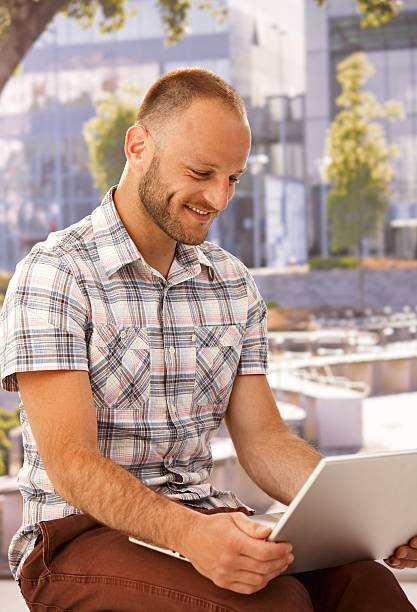 istock Happy man with laptop outdoors 467376207