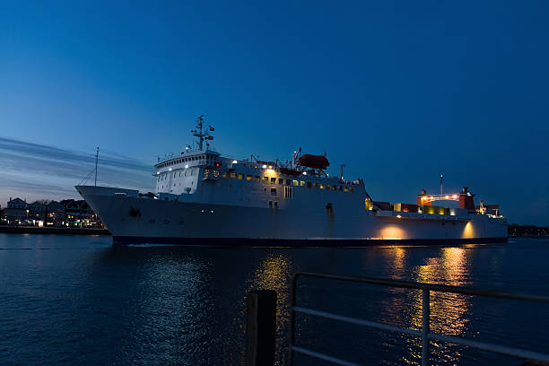 istock vessel passes a small port town in the late evening 467376362