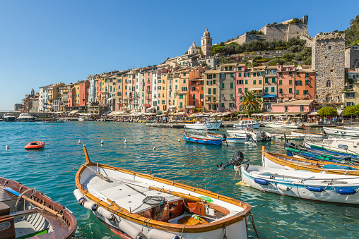 The harbour of Portovenere, Liguria, Italy. Small boats and colourful houses dominated by romanesque Church of San Lorenzo.