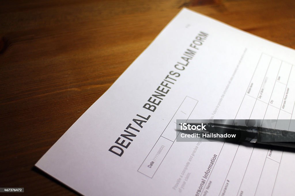 Dental Benefits Claim Someone filling out Dental Benefits Claim Form. 2015 Stock Photo