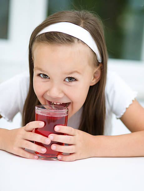 istock Little girl is drinking cherry juice 467379061