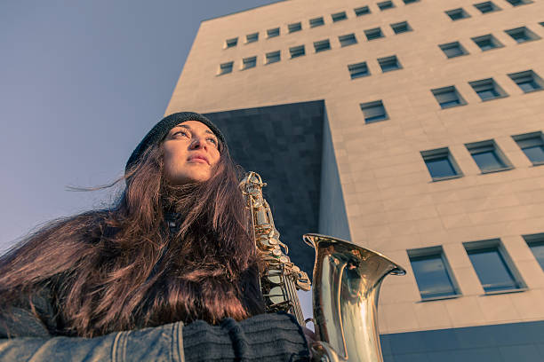istock Beautiful young woman with her saxophone 467382308