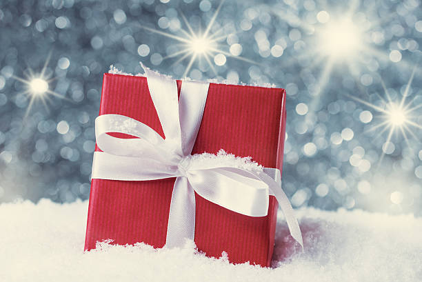 istock Red gift box in snow against abstract background 467388072