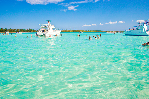 Isla Saona, Dominican Republic - April 2, 2014: Lots of tourists standing on a sandbank near Isla Saona in Dominican Republic. Isla Saona has one of the most beautiful beaches in the Caribbean. The area is part of the Parque Nacional del Este. Most of the tourists are not living on the island, they are picked up from their hotels in Bayahibe or Punta Cana and are spending a day on the island.