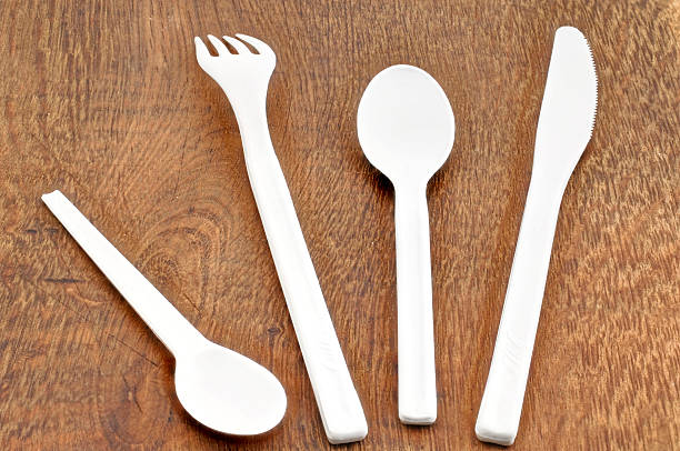 istock White plastic cutlery on wooden table 467388332