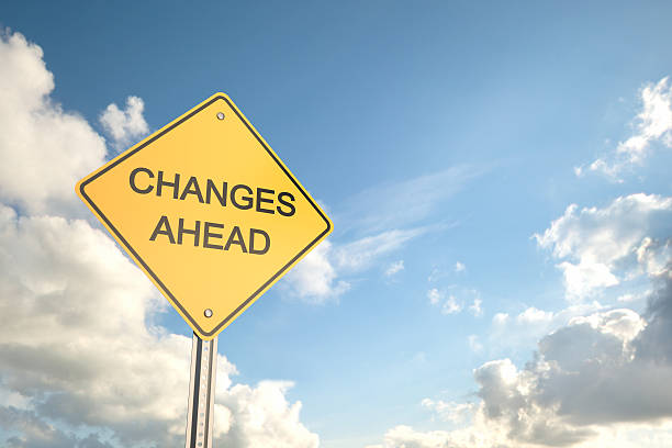 Yellow road sign saying changes ahead with blue cloudy sky
