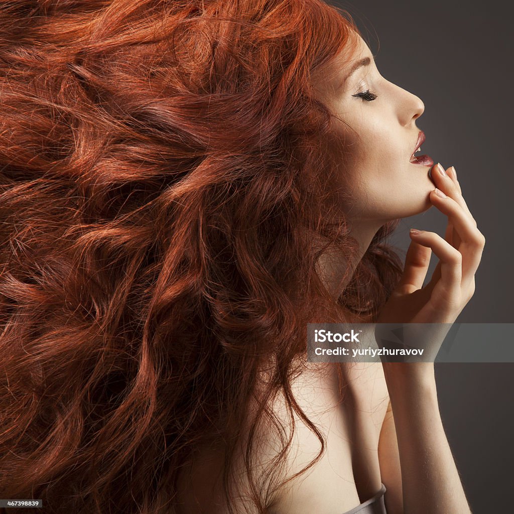 Beautiful woman with curly hairstyle against gray background Adult Stock Photo