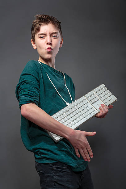 garoto adolescente usando um teclado de computador de violão - computer key computer keyboard computer keypad - fotografias e filmes do acervo