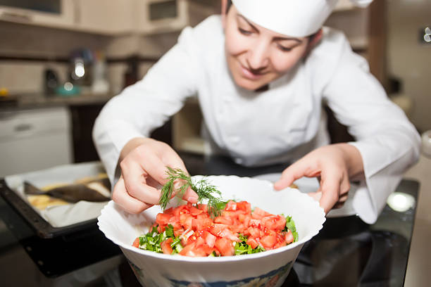 istock Female chef decorating dish with herb in kitchen 467399186