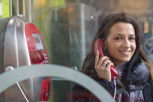 istock young happy woman calling from public phone 467404849