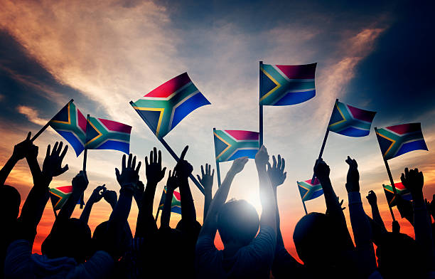 Group of People Waving South African Flags in Back Lit Group of People Waving South African Flags in Back Lit south africa flag stock pictures, royalty-free photos & images