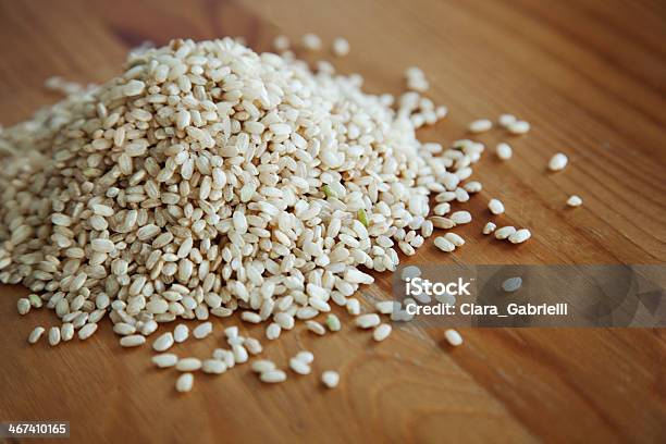 Brown Raw Rice On Wood Table Stock Photo - Download Image Now - Arborio Rice, Brown Rice, Carbohydrate - Food Type