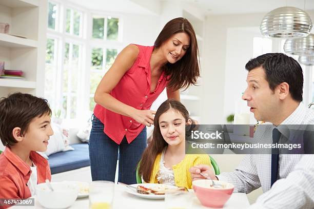 Family Having Breakfast Before Husband Goes To Work Stock Photo - Download Image Now