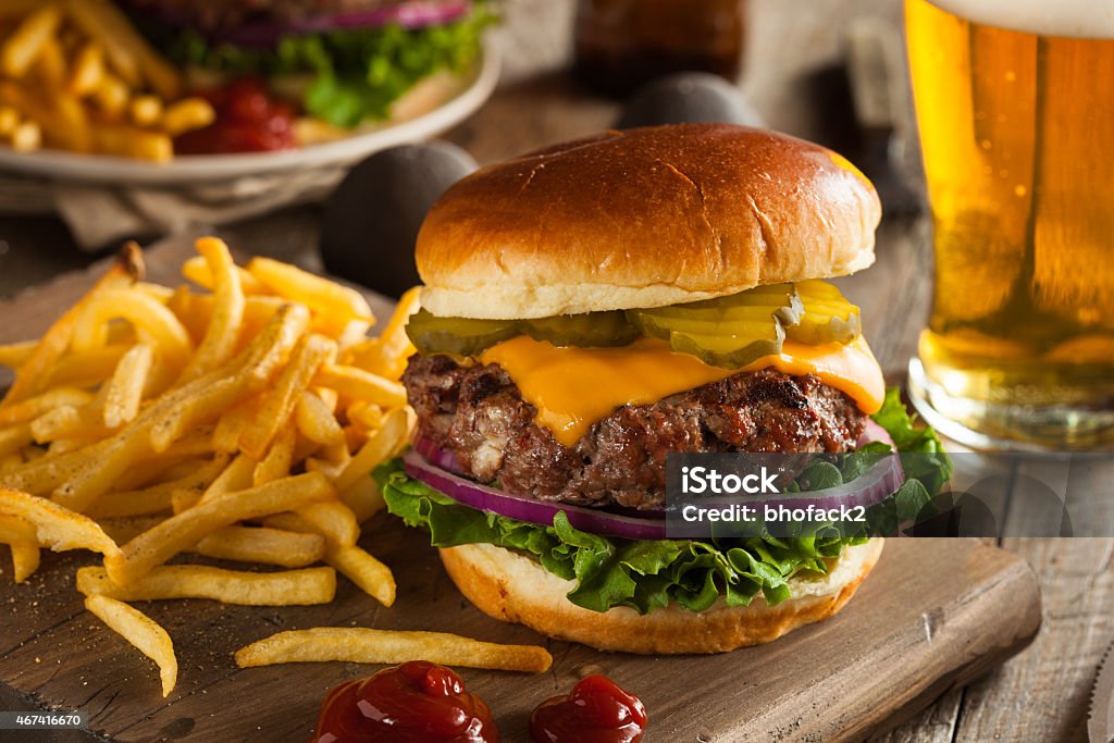 Huge grass fed bison hamburger with chips & beer Grass Fed Bison Hamburger with Lettuce and Cheese Burger Stock Photo