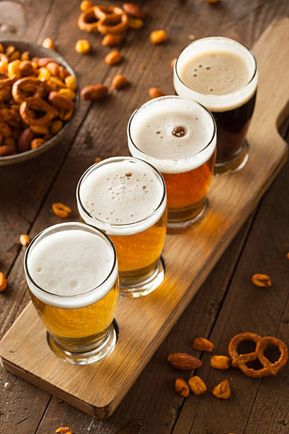 istock Four glasses of beer lined up on a board 467422088