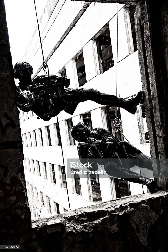 tactical rappeling Spec ops police officers SWAT during rope exercises with weapons 2015 Stock Photo