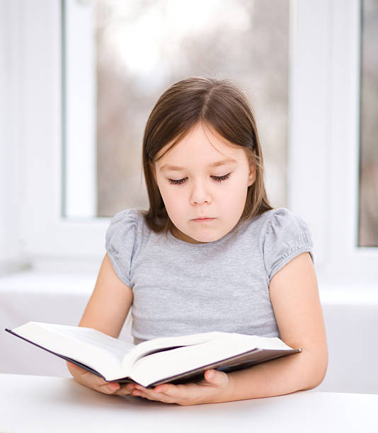 istock Little girl is reading a book 467426441