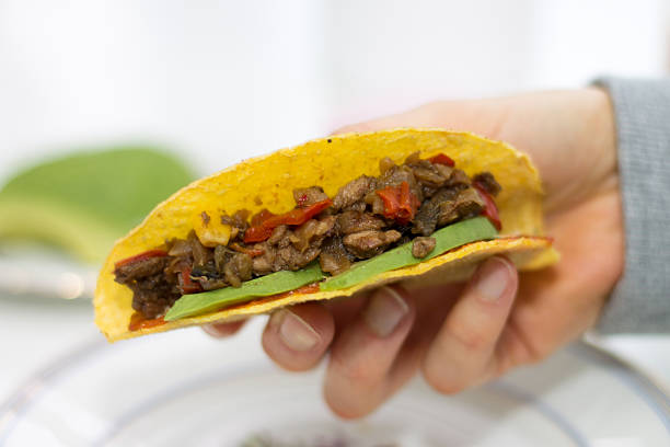 istock Close-up of hand holding a taco 467433241