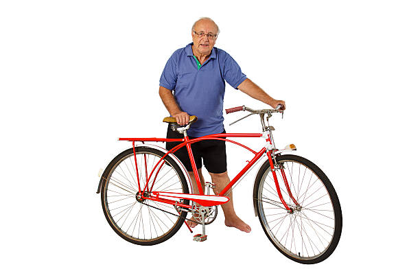 Senior man cycling in Viveiro. Covas beach and  sky in the background.  Viveiro, A Mariña area, Lugo province, Galicia, Spain.
