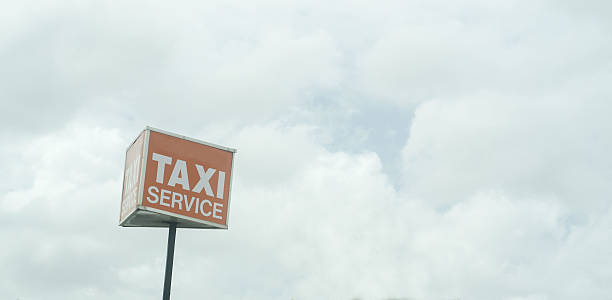 istock taxi service sign on post against overcast sky 467440974