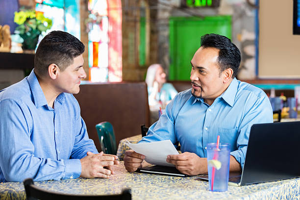 Restaurant manager interviewing Hispanic man for employment Restaurant manager interviewing Hispanic man for employment casual job interview stock pictures, royalty-free photos & images