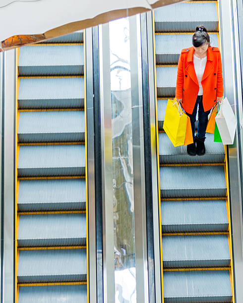 istock Female shopper standing on escalator 467447836