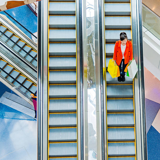 istock Female shopper standing on escalator 467447838