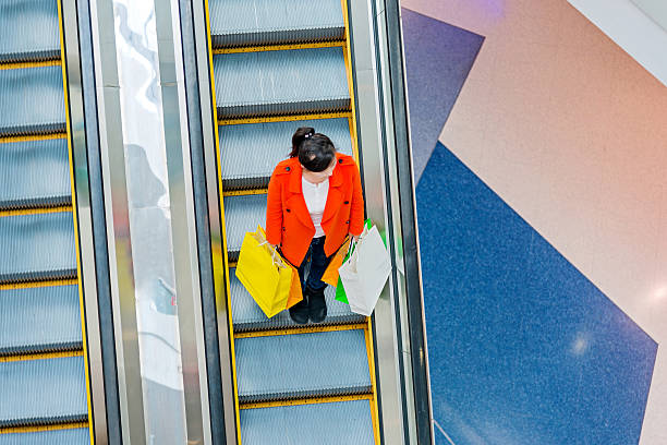 istock Female shopper standing on escalator 467447840