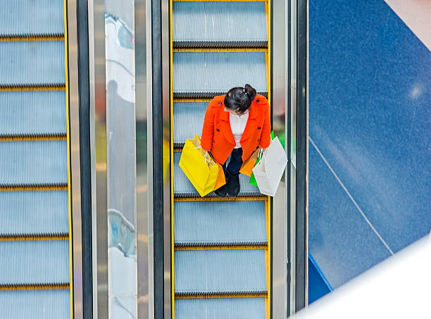 istock Female shopper standing on escalator 467447844