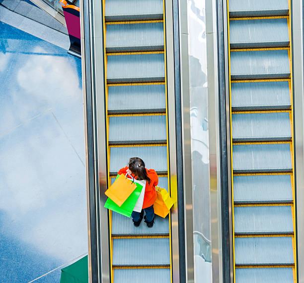 istock Female shopper standing on escalator 467447846
