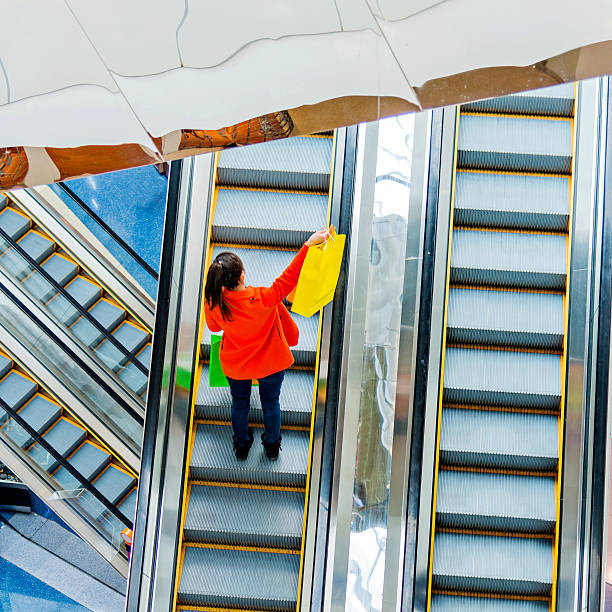 istock Female shopper standing on escalator 467447848
