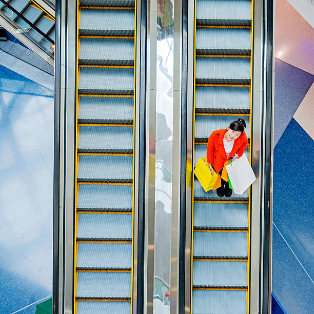 istock Female shopper standing on escalator 467448632