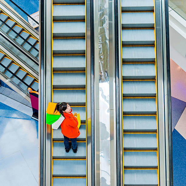 istock Female shopper standing on escalator 467448634