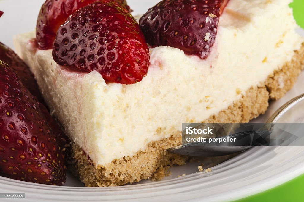 Strawberry cheesecake detail a delicious strawberry cheesecake in a white plate on a green background Baked Pastry Item Stock Photo