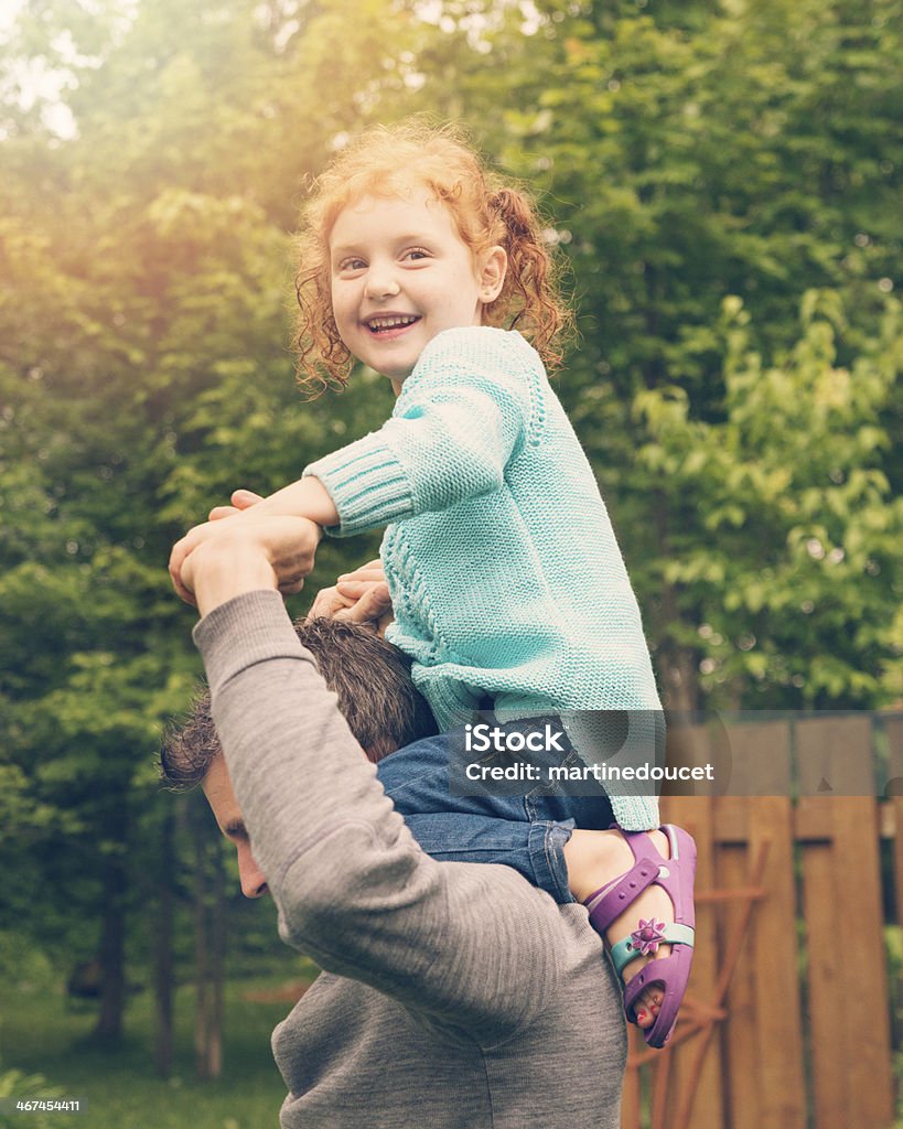 Szczęśliwy dziecko tata ramionami w górę na podmiejskich podwórku. - Zbiór zdjęć royalty-free (Wysoko)