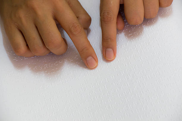 istock Close up of male hand reading braille text 467454440