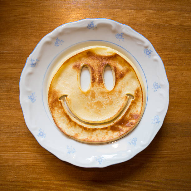 pan cake with smiley face on plate stock photo
