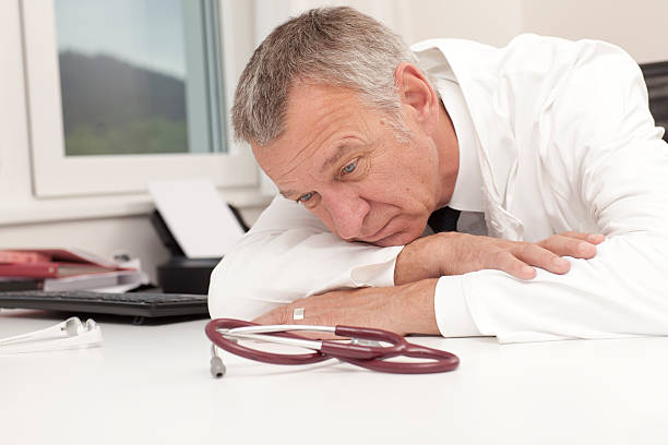 Overworked doctor having burn out stock photo