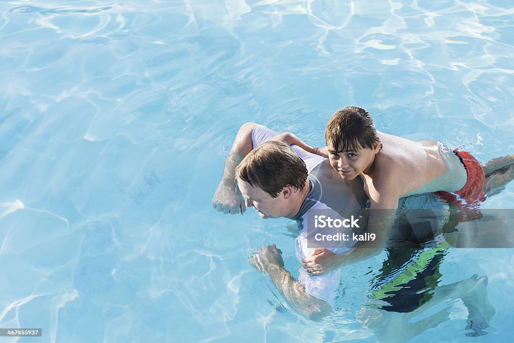 Father and son in pool Father (30s) and son (10-11 years) having fun in swimming pool. 10-11 Years Stock Photo