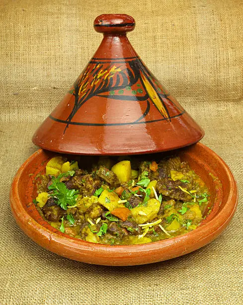 Beef Stew in Tajine. Traditional dish cooked in a different way and flavoured with saffron, lemon zest and ginger. Served with potatoes.