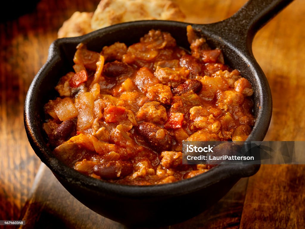 Chili with Red Kidney Beans Chili with Ground Beef, Red Kidney Beans, Peppers, Onions and a Fresh Made Biscuit in a Cool Cast Iron Serving Pot -Photographed on Hasselblad H3D2-39mb Camera 2015 Stock Photo