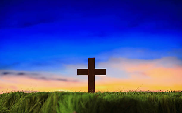 istock cross silhouette on grass with sunset background 467463051