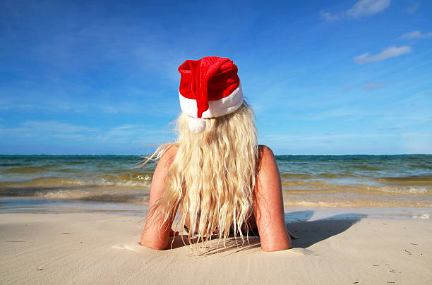 istock Woman in Santa hat on beach 467464129