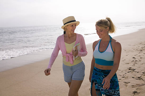 Mother and daughter walking on beach